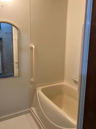 a bathroom with a bath tub and a mirror at 空彩 -sorairo- 札幌から富良野への最短ルート in Mikasa