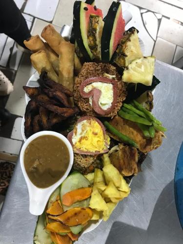 a plate of food with a variety of foods and dipping sauce at Bojo Beach Resort in Bortianor