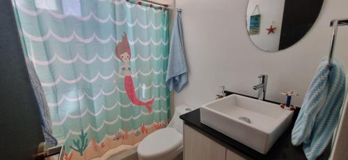 a bathroom with a sink and a shower curtain at CARRIBEAN DELUXE Apartment in Playa del Carmen