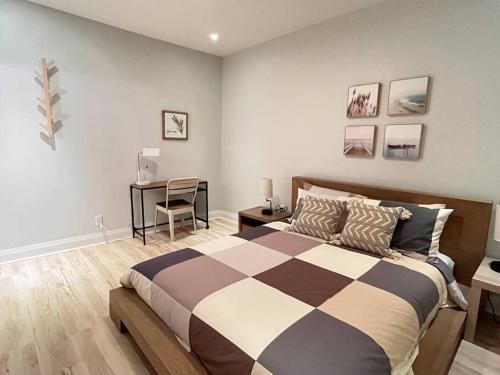 a bedroom with a bed and a desk with a chair at Stylish 3-bdrm suite w free Parking in Kitchener