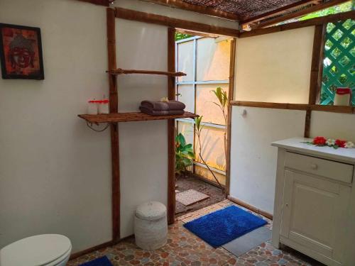 un piccolo bagno con servizi igienici e finestra di Te Fitii Garden & Beach a Fare (Huahine Nui)