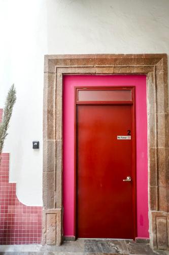 a red and pink door in a building at Casa Morelos StayHouse in San Luis Potosí