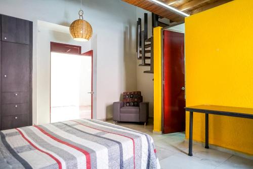 a bedroom with a bed and a yellow wall at Casa Morelos StayHouse in San Luis Potosí