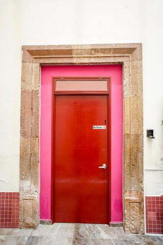 a red and pink door on a building at Casa Morelos StayHouse in San Luis Potosí