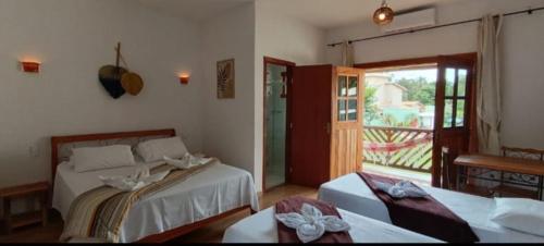 a bedroom with two beds and a window at Pousada Real Cipo in Serra do Cipo