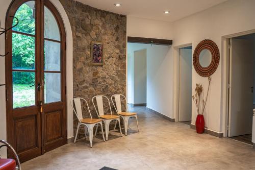 a hallway with chairs and a stone wall at RUNA YAKU KAUNAZ in Salta