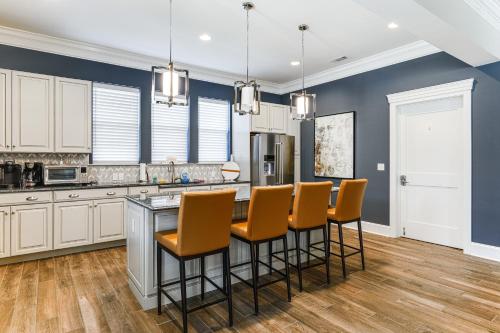 a kitchen with white cabinets and a island with bar stools at 5 Mi to Bethany Beach Resort-Style Gem with Pools! in Ocean View