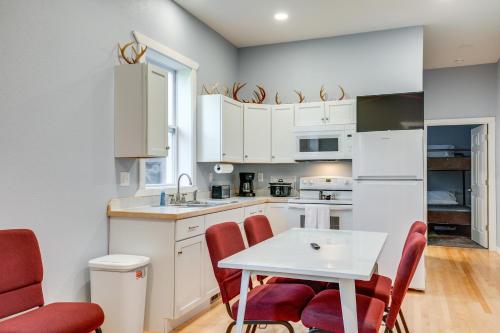 a kitchen with white cabinets and a table and chairs at 15 Mi to Lake Superior Renovated Church with Grill in Toivola