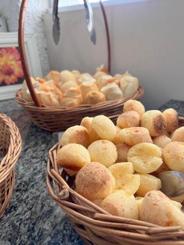 twee manden met brood en manden met voedsel op een aanrecht bij Pousada Golden House - Próxima ao Thermas no Centro de Aguas in Águas de São Pedro