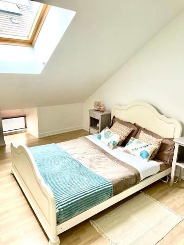 une chambre avec un grand lit dans un grenier dans l'établissement Maison à 7 min de Dijon, à Ruffey-lès-Échirey