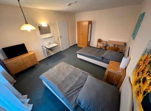 un soggiorno con 2 letti e una TV di Turp Residenz a Blomberg