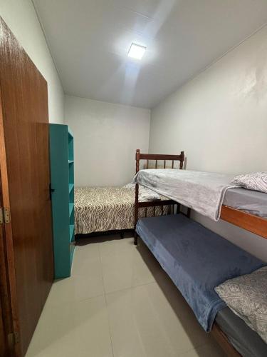 a small room with two bunk beds and a door at casa canasvieiras 100 m praia in Florianópolis