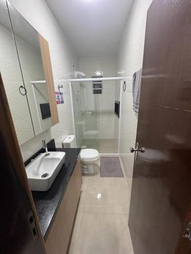 a bathroom with a shower and a sink and a toilet at casa canasvieiras 100 m praia in Florianópolis