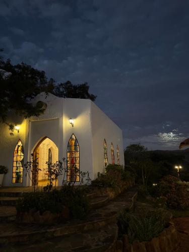 a white church with windows at night at El Pueblito Hotel Boutique in Samaipata