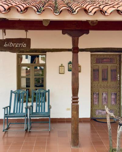 two blue benches sitting in front of a building at El Pueblito Hotel Boutique in Samaipata