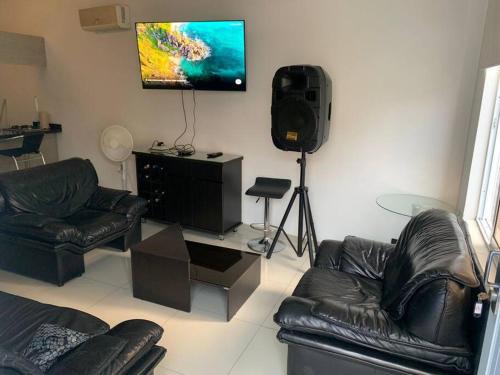 a living room with leather furniture and a flat screen tv at Apartamento en ciudad jardín #7 in Cali