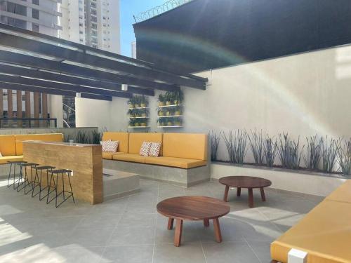 a rooftop patio with a couch and tables and a rainbow at 2307 Uwin Brooklin melhor custo benefício ao lado do metrô in Sao Paulo