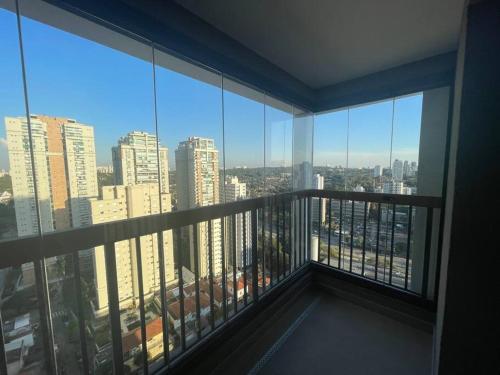 a room with a balcony with a view of a city at 2307 Uwin Brooklin melhor custo benefício ao lado do metrô in Sao Paulo
