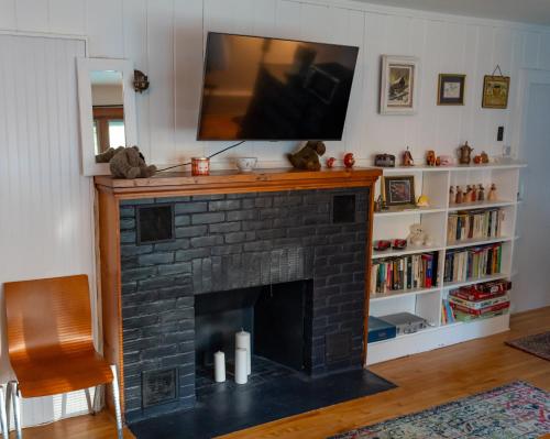 a living room with a fireplace with a flat screen tv at Air Vermont Apartment in South Burlington