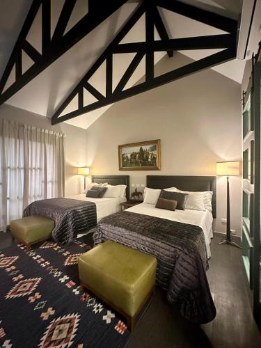 a hotel room with two beds and a rug at Boutique Hotel La Casona in Valle de Ángeles