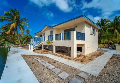 a house with a balcony and a palm tree at Magnolia's By The Sea in Big Pine Key