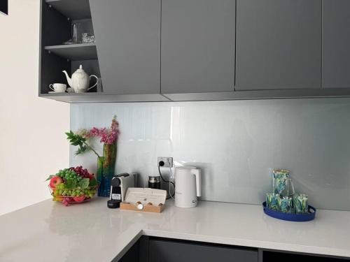a white kitchen counter top with flowers on it at Luxury Villa- Long Bay Manhattan in Auckland