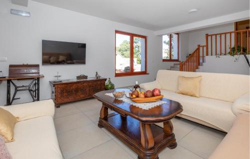 a living room with a table with a bowl of fruit on it at Amazing Home In Kula Norinska With Wifi in Kula Norinska