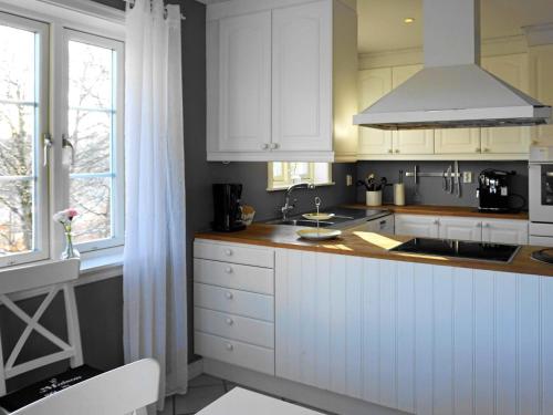 a kitchen with white cabinets and a sink at 8 person holiday home in ELLÖS in Ellos
