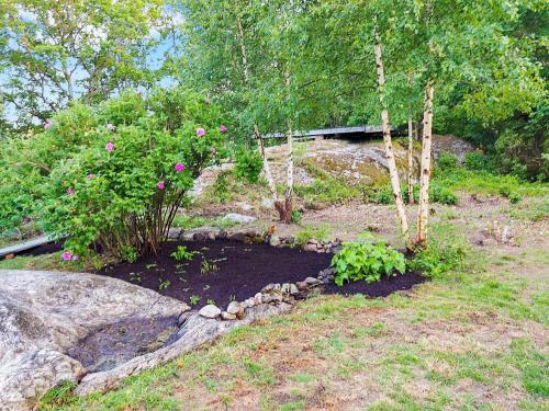 a garden with trees and flowers in the dirt at 8 person holiday home in ELLÖS in Ellos