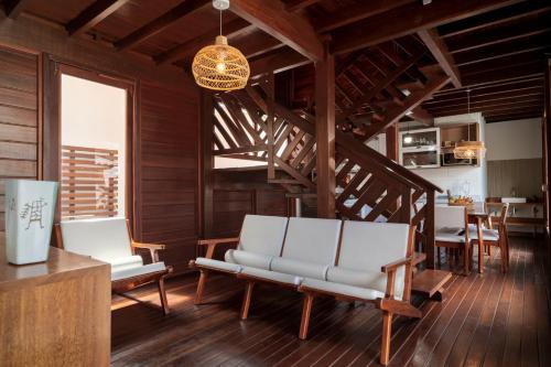 a living room with two white chairs and a staircase at Villa do Ze in Jijoca de Jericoacoara