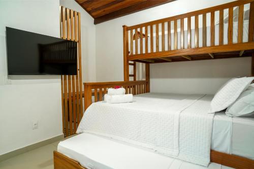 a bedroom with two bunk beds and a flat screen tv at Villa do Ze in Jijoca de Jericoacoara
