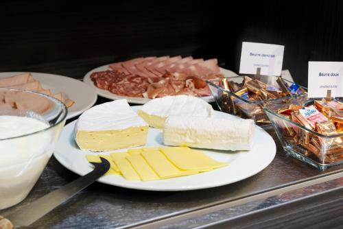a table topped with plates of cheese and other foods at Campanile Metz Nord - Talange in Talange
