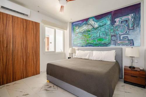 Un dormitorio con una cama y un cuadro en la pared. en Avida Residence, en Puerto Vallarta