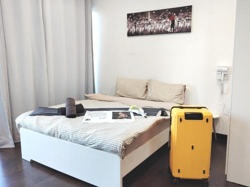 a bed with a yellow suitcase in a room at Almas Suites Poolview Netflix 100mbps BySTAY in Nusajaya