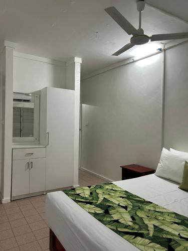 a bedroom with a bed and a ceiling fan at Yatu Lau Transit Hotel in Nadi