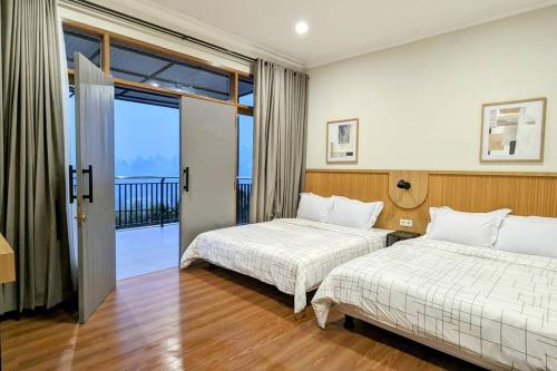 une chambre d'hôtel avec deux lits et un balcon dans l'établissement Cottonwood Villa Rotensia BBQ Pool Pingpong, à Bandung