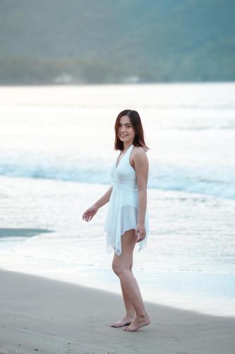 a woman in a white dress standing on the beach at Bucana Beach House North El Nido in El Nido