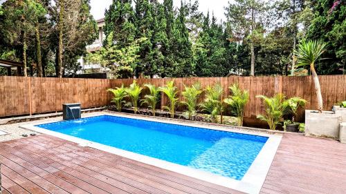 - une piscine dans un jardin avec une clôture en bois dans l'établissement Cottonwood Villa Rotensia BBQ Pool Pingpong, à Bandung