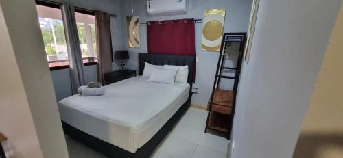 a small bedroom with a bed and a ladder at Ballena Rey Hotel in Uvita