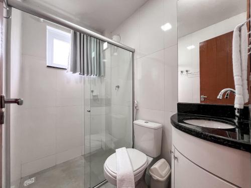 ein Badezimmer mit Toilette und Glasdusche in der Unterkunft Casa para temporada em Arraial D'ajuda in Porto Seguro