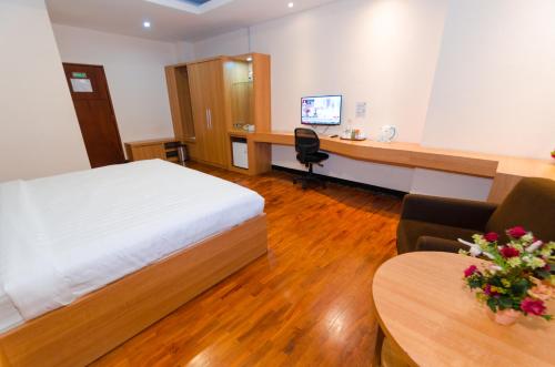 a hotel room with a bed and a desk with a computer at Graha Widya Bhakti at STIESIA Surabaya in Surabaya