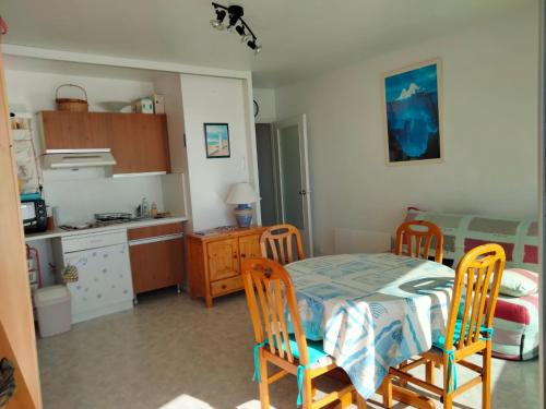 une cuisine avec une table et des chaises dans une pièce dans l'établissement Studio tout confort face à la mer avec balcon - Les Sables-d'Olonne - FR-1-331-41, à Les Sables-dʼOlonne