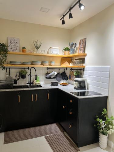 a kitchen with black cabinets and a sink at 2-Bedroom Condo in Antipolo with Nature or Farm View in Antipolo