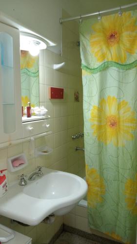 a bathroom with a sink and a shower curtain with flowers at Corrientes Grand Apart in Corrientes
