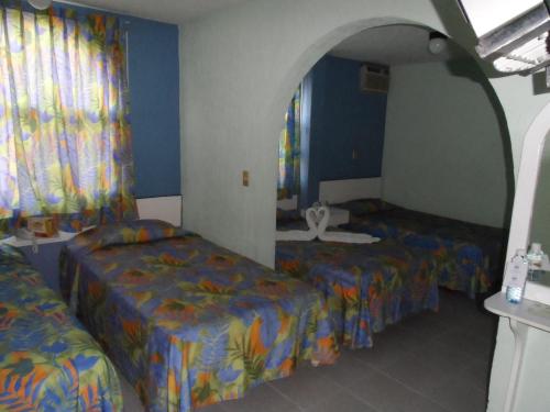 two beds in a room with blue walls and curtains at Dorados Conventions & Resort in Oaxtepec