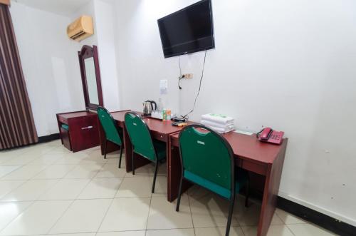 a room with a table and chairs and a television at Graha Widya Bhakti at STIESIA Surabaya in Surabaya