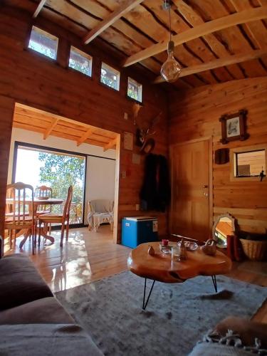 a living room with a couch and a table at Cabaña con vista al Lago Colico in Puerto Corrales