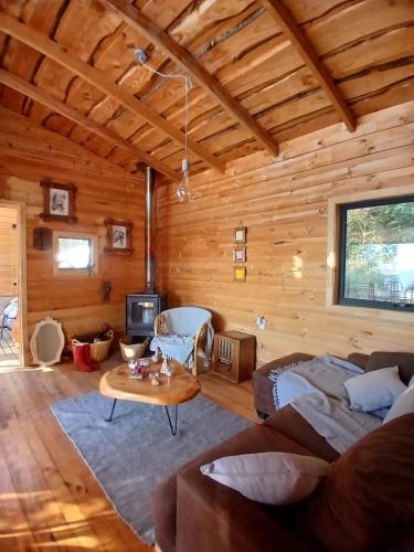 a log cabin living room with a couch and a table at Cabaña con vista al Lago Colico in Puerto Corrales