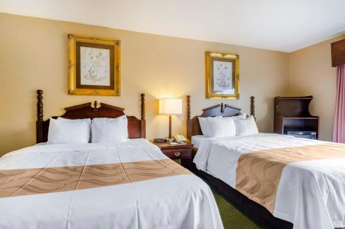 a hotel room with two beds with white sheets at Precious Hotel in Carthage