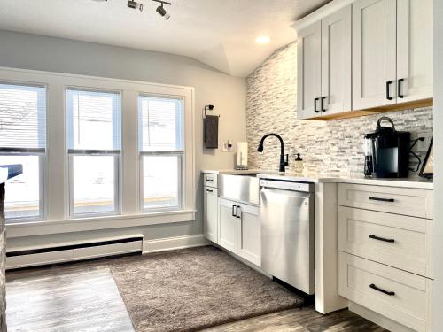 une cuisine avec des armoires blanches et des appareils électroménagers blancs dans l'établissement Rockford IL 2BD Upper Queen Bed, Patio & Fast WiFi, à Rockford